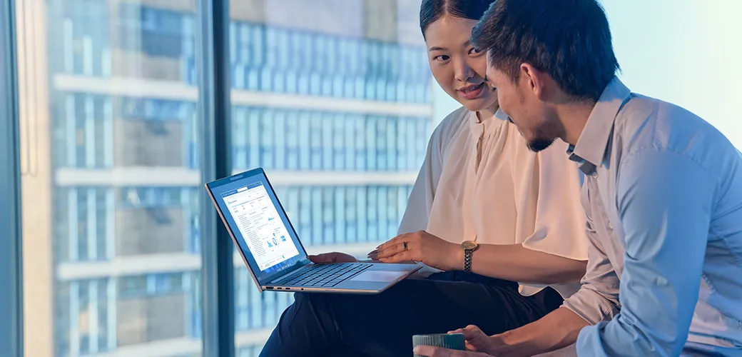 Coworkers discussing a presentation using an HP EliteBook 8 G1a