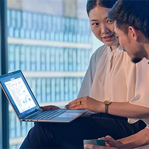 Coworkers discussing a presentation using an HP EliteBook 8 G1a